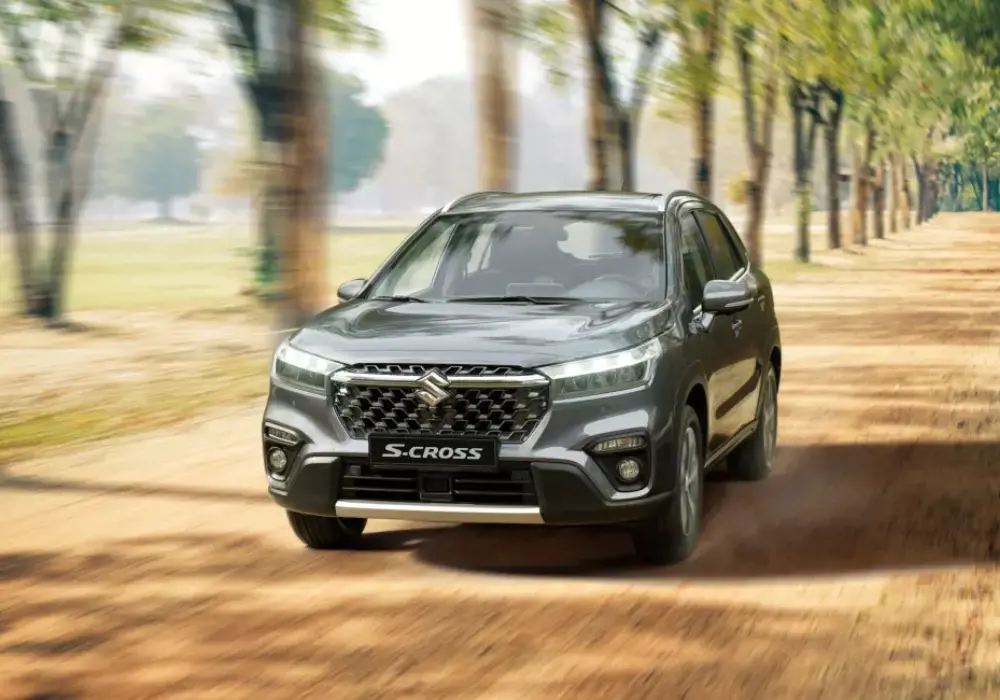 Suzuki S-Cross gris de nueva generación recorriendo un camino forestal.